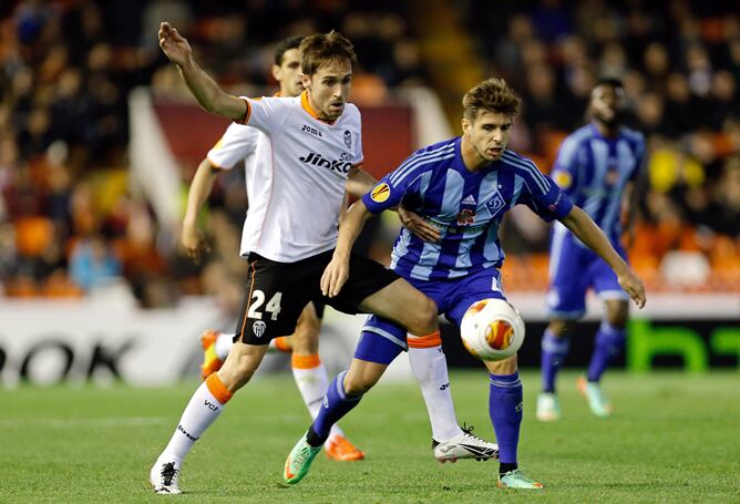 El centrocampista del Valencia Míchel Herrero (i) disputa un balón con el centrocampista del Dinamo Kiev Miguel Veloso