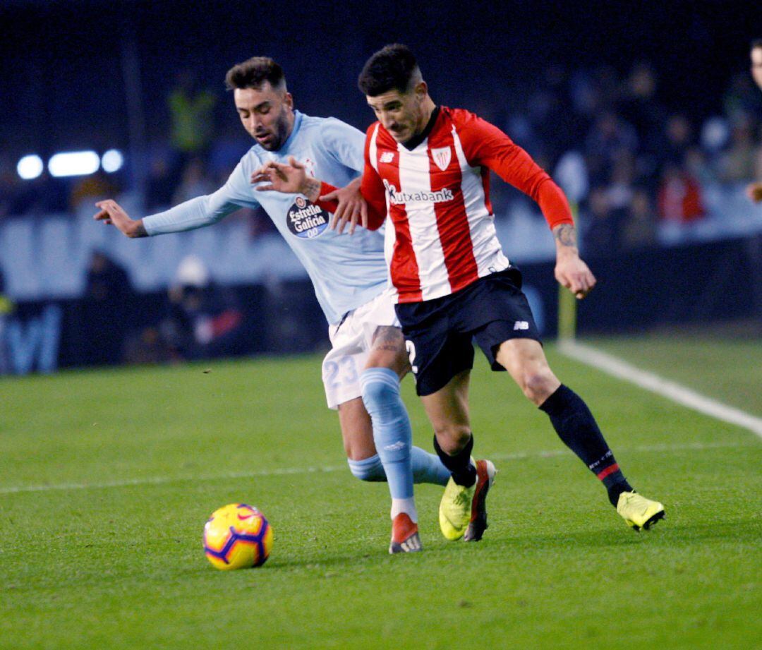 El defensa del Athletic de Bilbao Yuri Berchiche (d) pelea un balón con el centrocampista del Celta, Brais Méndez (i), en el partido de liga en Primera División que se disputa esta noche en el estadio de Balaídos