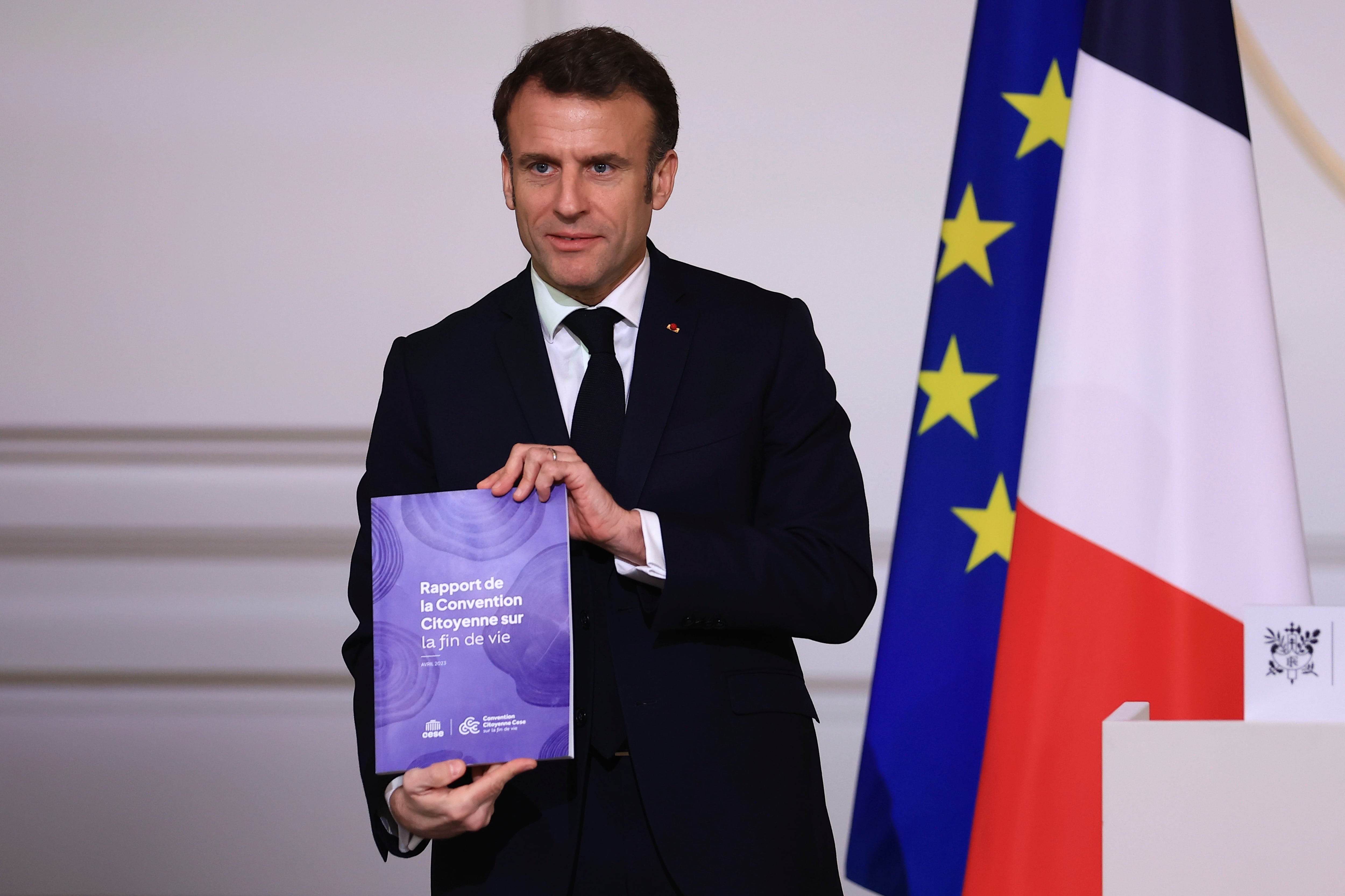 Emmanuel Macron posa con el informe de la comisión ciudadana sobre la regulación de la eutanasia