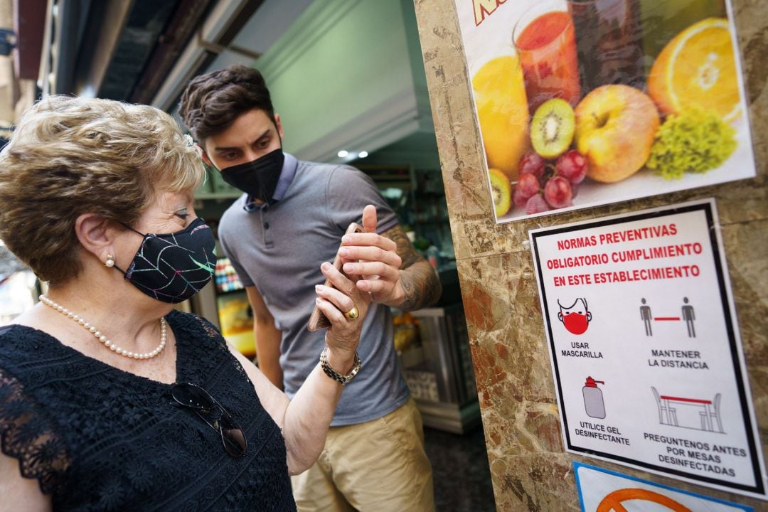 Personal de una cafetería de Santa Cruz de Tenerife, comprueba el certificado COVID de una clienta.