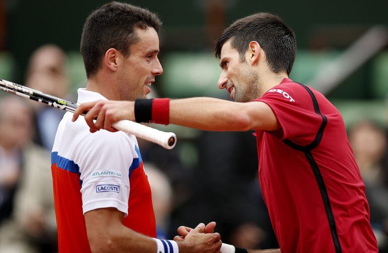 El tenista serbio Novak Djokovic (d) abraza al español Roberto Bautista tras el partido que enfrentó a ambos en los octavos de final del torneo de Roland Garros en París (Francia) hoy, 1 de junio de 2016. EFE-Yoan Valat