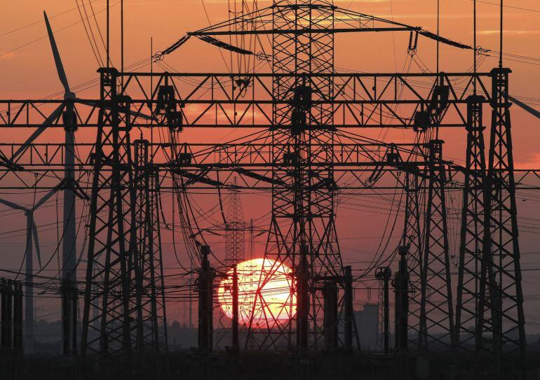 En la imagen, una puesta de sol junto al tendido eléctrico y unos molinos de viento. EFE/Archivo