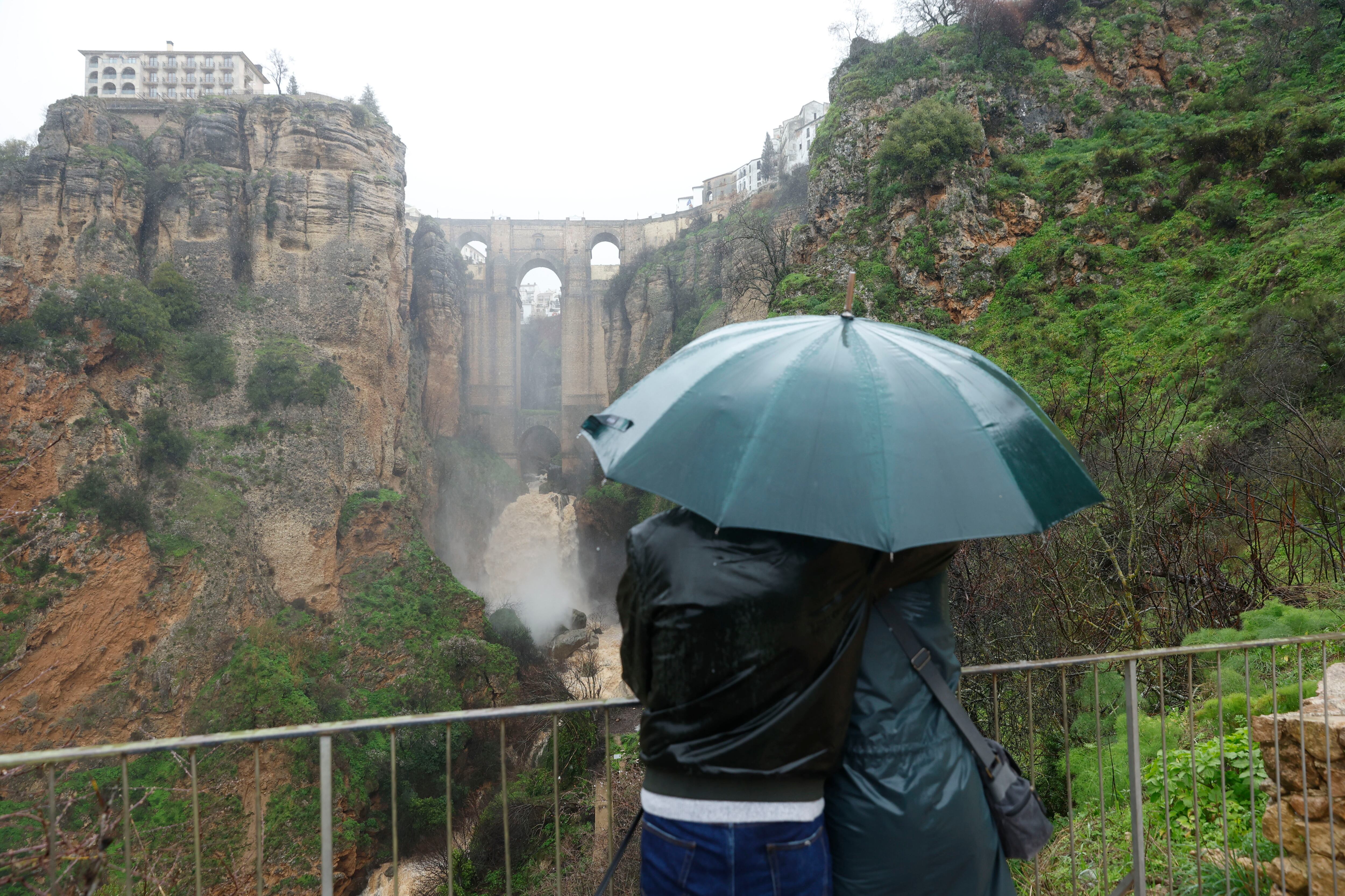RONDA (MÁLAGA), 04/02/2026.- Dos personas miran hacia el puente de la localidad de Ronda (Málaga) este miércoles en el que el paso de la borrasca Leonardo deja desalojos, poblaciones aisladas y cortes de carreteras en España, con riesgo extremo de inundaciones y desbordamientos por lluvias extraordinariamente abundantes sobre todo en Andalucía, en alerta roja, que podrán acumular en zonas de Cádiz y Málaga más de 400 litros por metro cuadrado en solo dos días. EFE/ Jorge Zapata