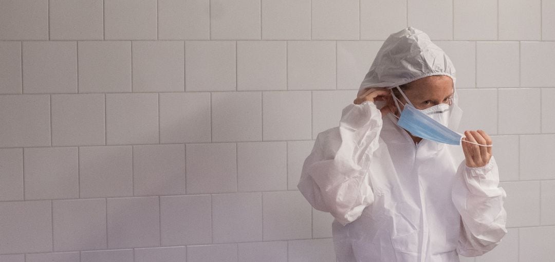 Una enfermera se quita la mascarilla a la salida del hospital.