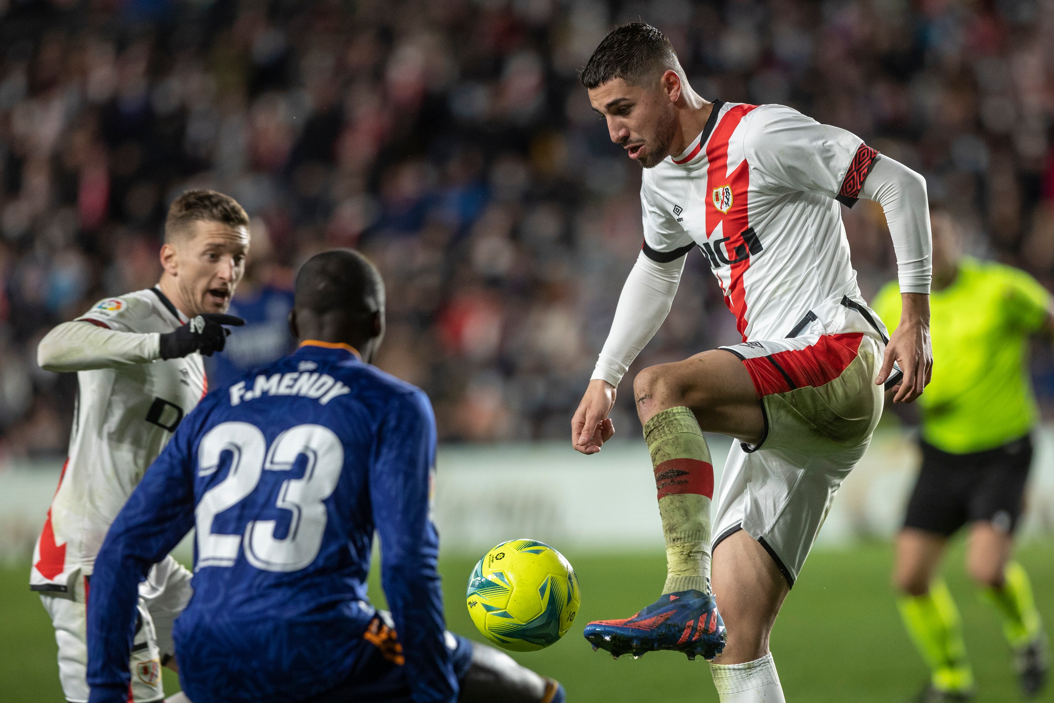 El centrocampista del Rayo Vallecano, Santi Comesaña, intenta controlar el balón ante el defensa francés del Real Madrid, Ferland Mendy, durante el encuentro correspondiente a la jornada 26 de primera división que disputan hoy sábado en el estadio de Vallecas, en Madrid.