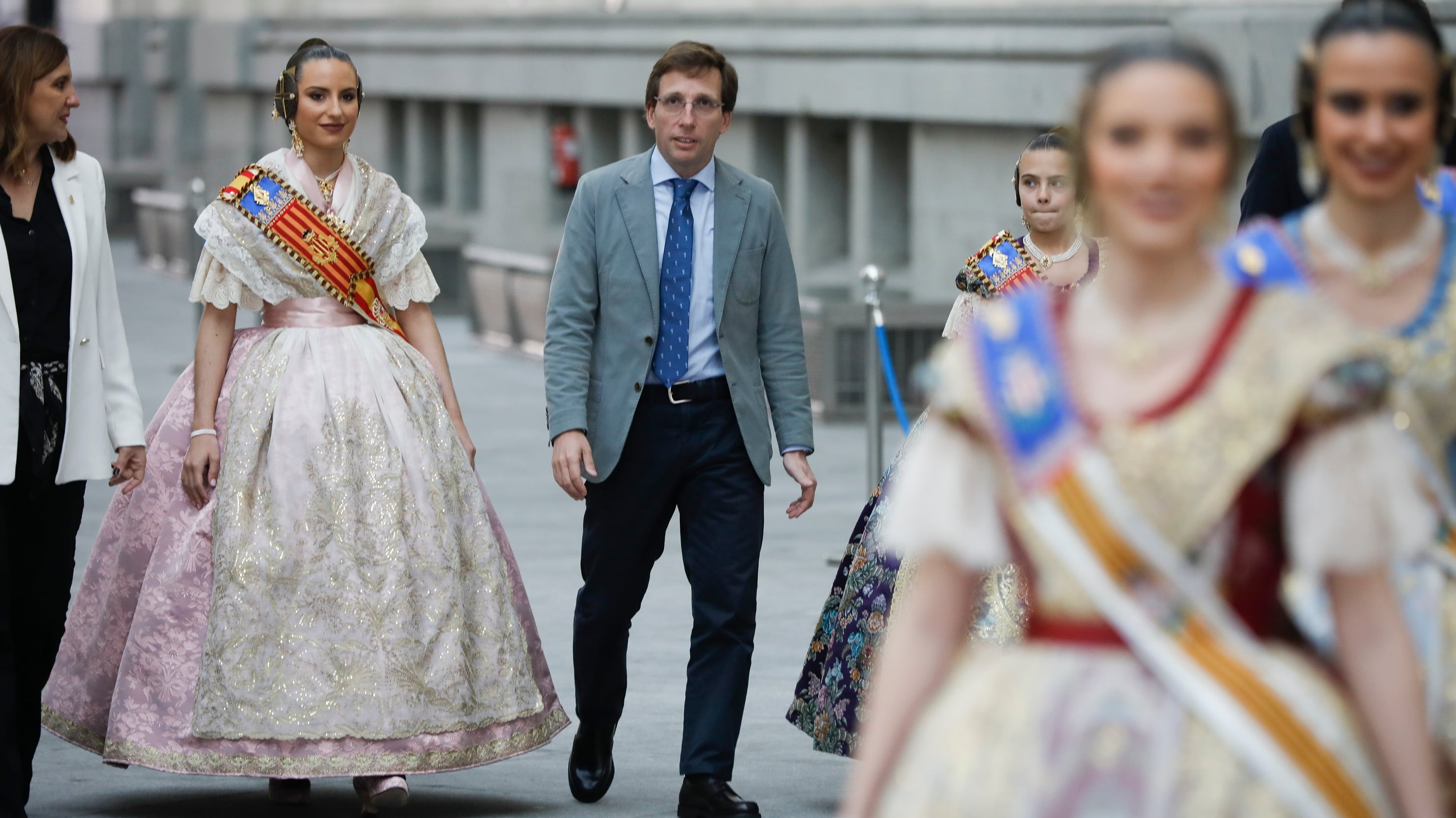 El alcalde de Madrid, Jose Luis Martínez Almeida (c), recibe a la alcaldesa de Valencia, María José Catalá (i), junto a las falleras mayores de Valencia, acompañadas por sus cortes de honor este domingo en el Palacio de Cibeles de Madrid, antes de la Mascletá que tendrá lugar en el Puente del Rey, en la zona de Madrid Río. EFE/David Fernández