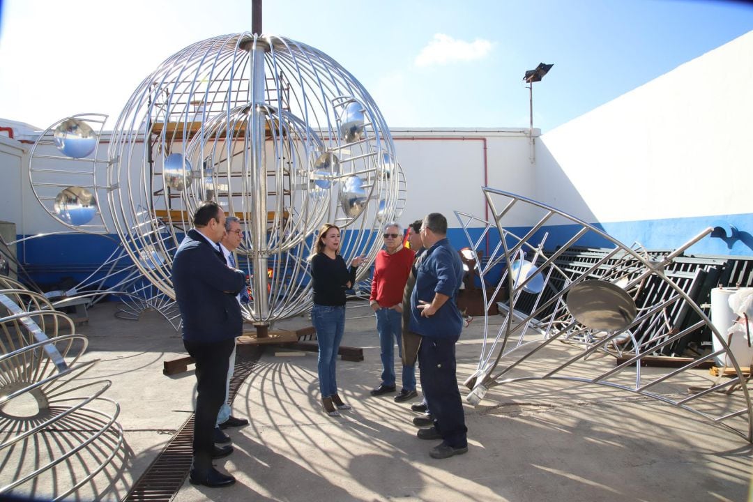 La presidenta del Cabildo de Lanzarote con algunos de los trabajadores que restauran el juguete de viento.