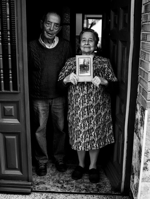 Regina Robledo en la puerta de su casa, con la foto de su padre, en la mano