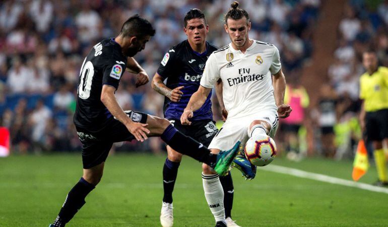 El delantero galés del Real Madrid, Gareth Bale (d), disputa el balón frente al delantero uruguayo del Club Deportivo Leganés, Michael Santos (i), durante el partido correspondiente a la tercera jornada de LaLiga Santander, que el Real Madrid y el Leganés