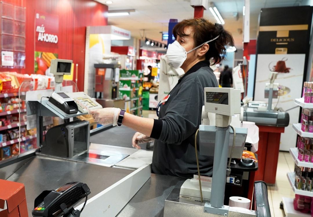 Empleada con mascarilla por coronavirus en un supermercado