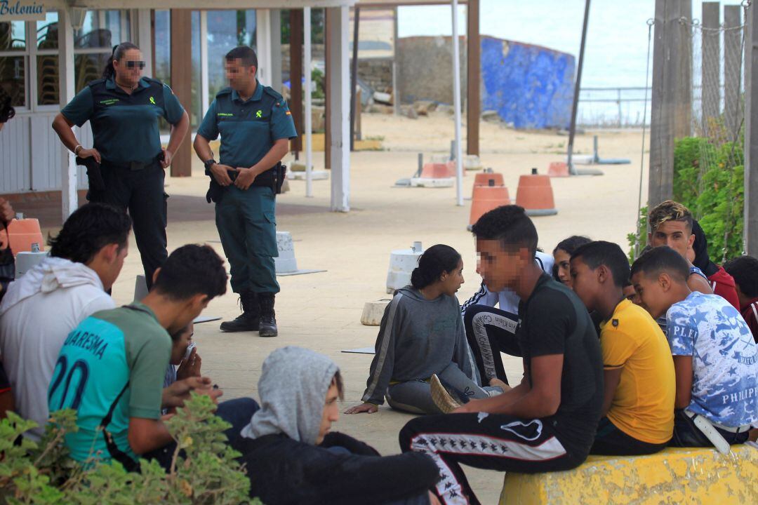 Menores esperando en la playa tras ser rescatados en un patera en aguas del Estrecho de Gibraltar