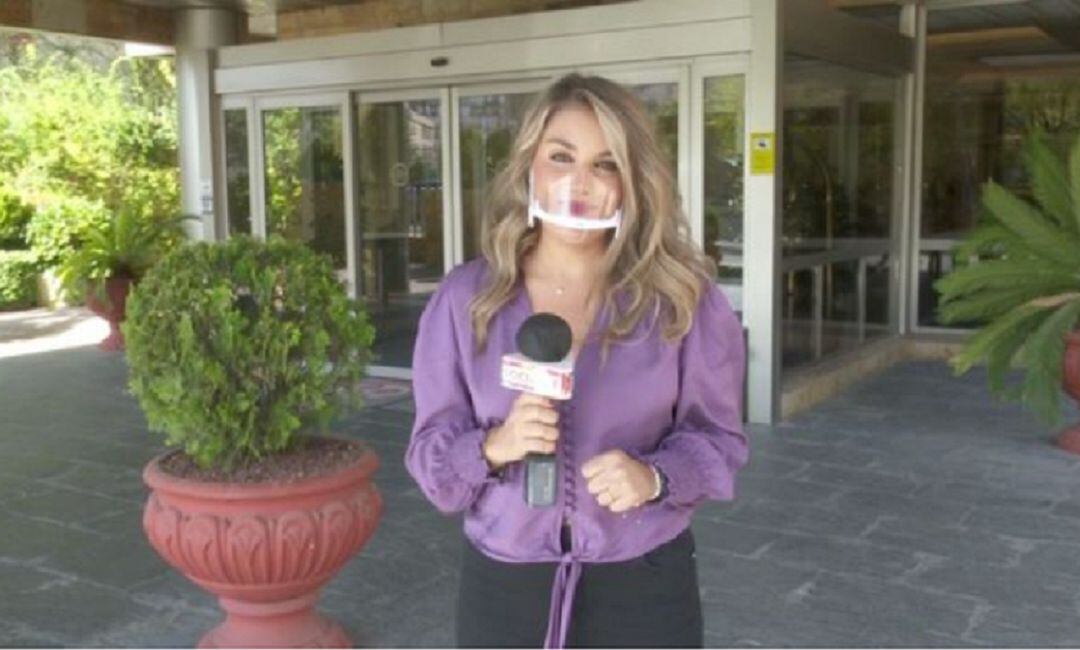 La reportera con una mascarilla de plástico.