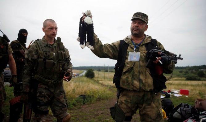 Un separatista prorruso tiene un juguete de peluche que se encuentra en el lugar del accidente del vuelo Malaysia Airlines MH17