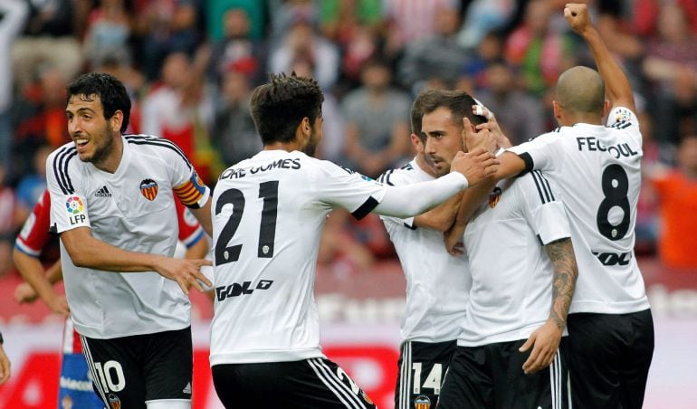 El delantero del Valencia Paco Alcácer recibe la felicitación de sus compañeros después de hacer el 0-1 en El Molinón.