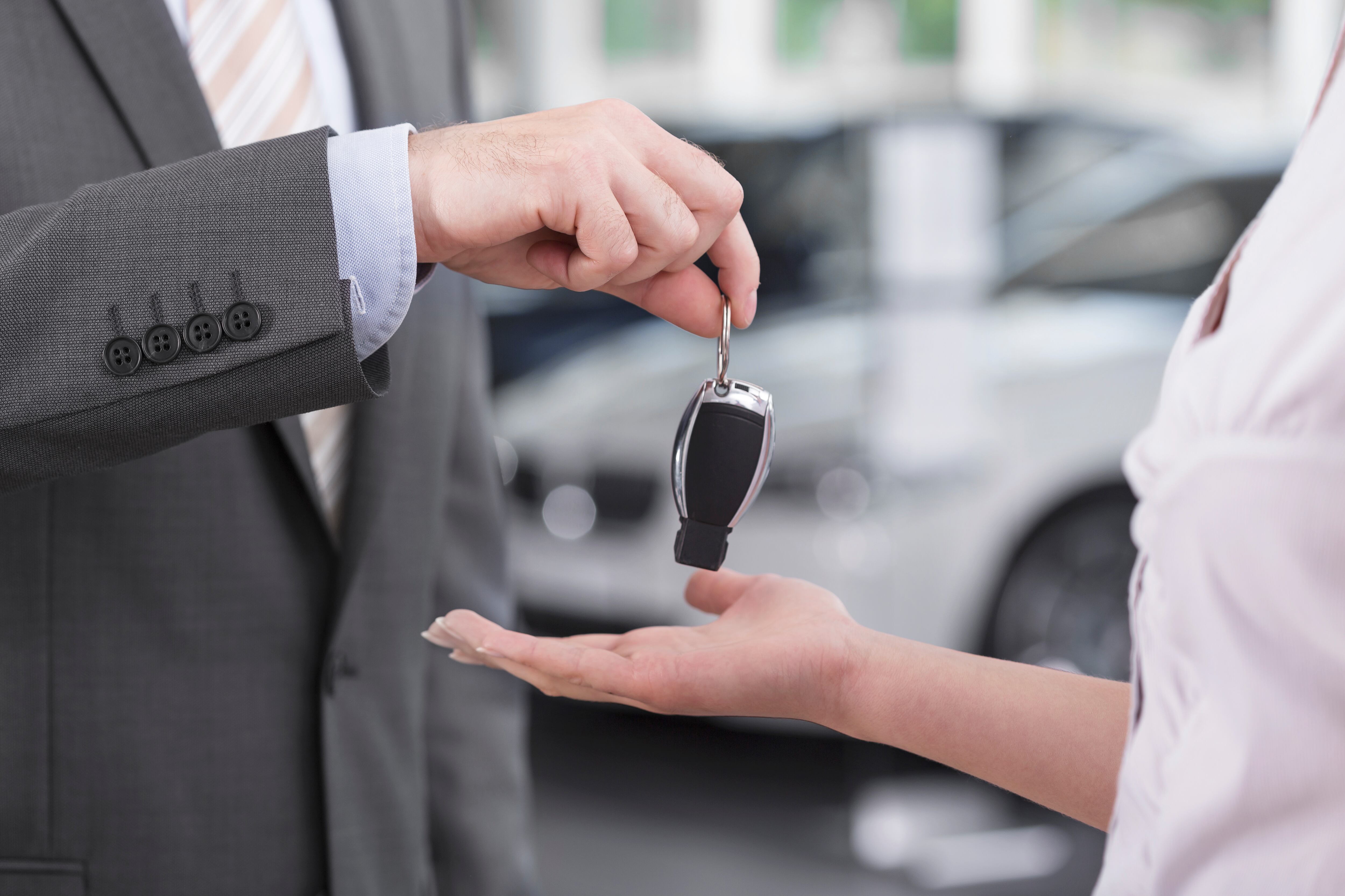 Un empleado le da las llaves de un coche a una mujer.