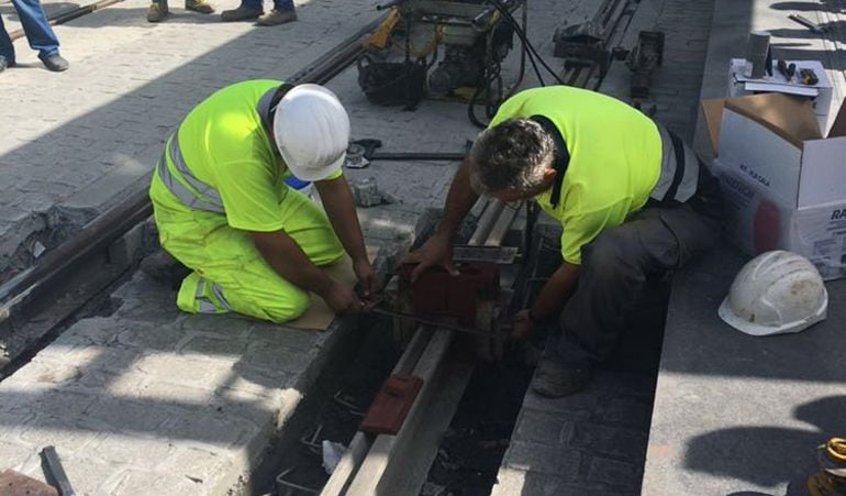 Dos operarios colocan la última pieza del Metro de Granada.