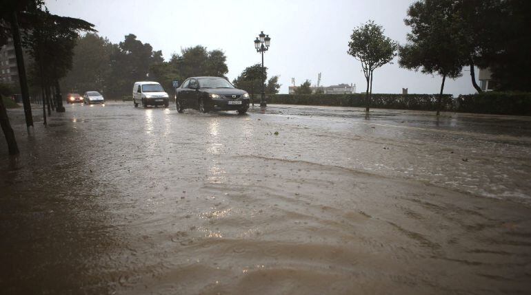 Varios coches circulan por una calle inundada en la falda del Monte del Castro, cerca del Ayuntamiento de Vigo