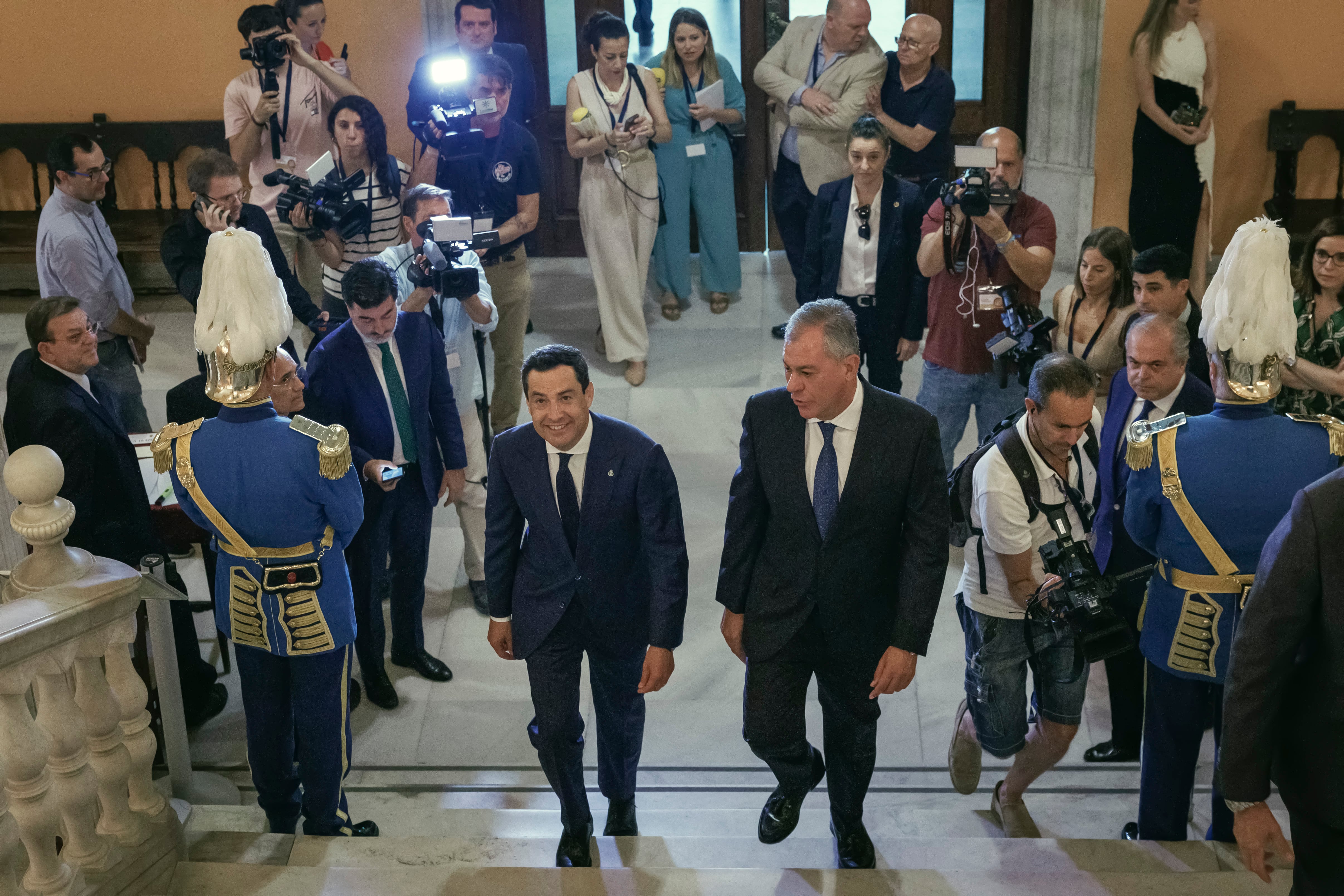 El nuevo alcalde de Sevilla, José Luis Sanz (d), del PP, y el presidente de la Junta, Juanma Moreno (i), subiendo las escaleras del Ayuntamiento poco antes del acto de toma de posesión tras las elecciones municipales del 28 de mayo.