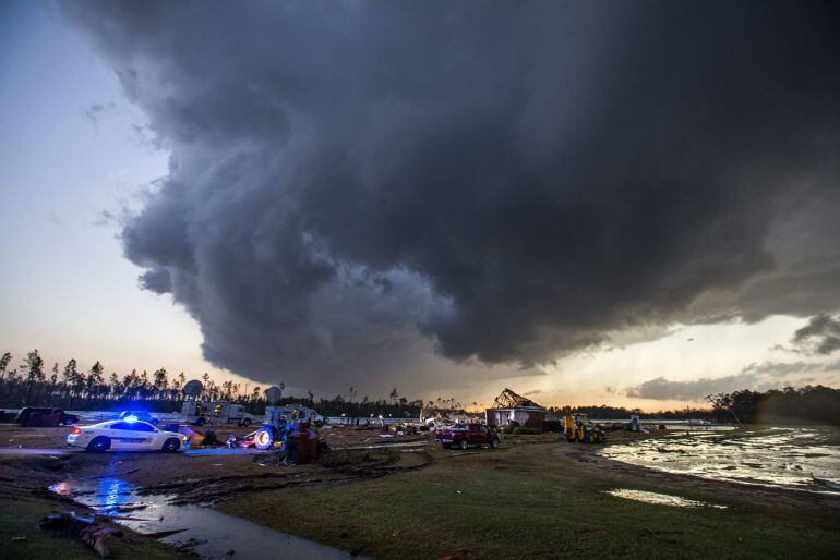 Un tornado se aproxima al equipo de emergencia cerca de una casa que fue partida en la mitad por la fuerte tormenta