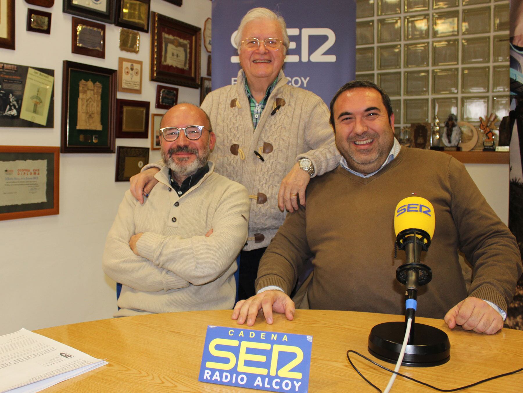 El secretario de la Asociación de San Jorge, Pau Acosta, y el ponente de sillas, Alberto Rivas, en el estudio central de Radio Alcoy junto a Paco Aznar