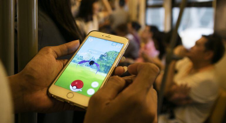 Un hombre jugando a Pok&amp;amp;eacute;mon Go en el tren de Bankok