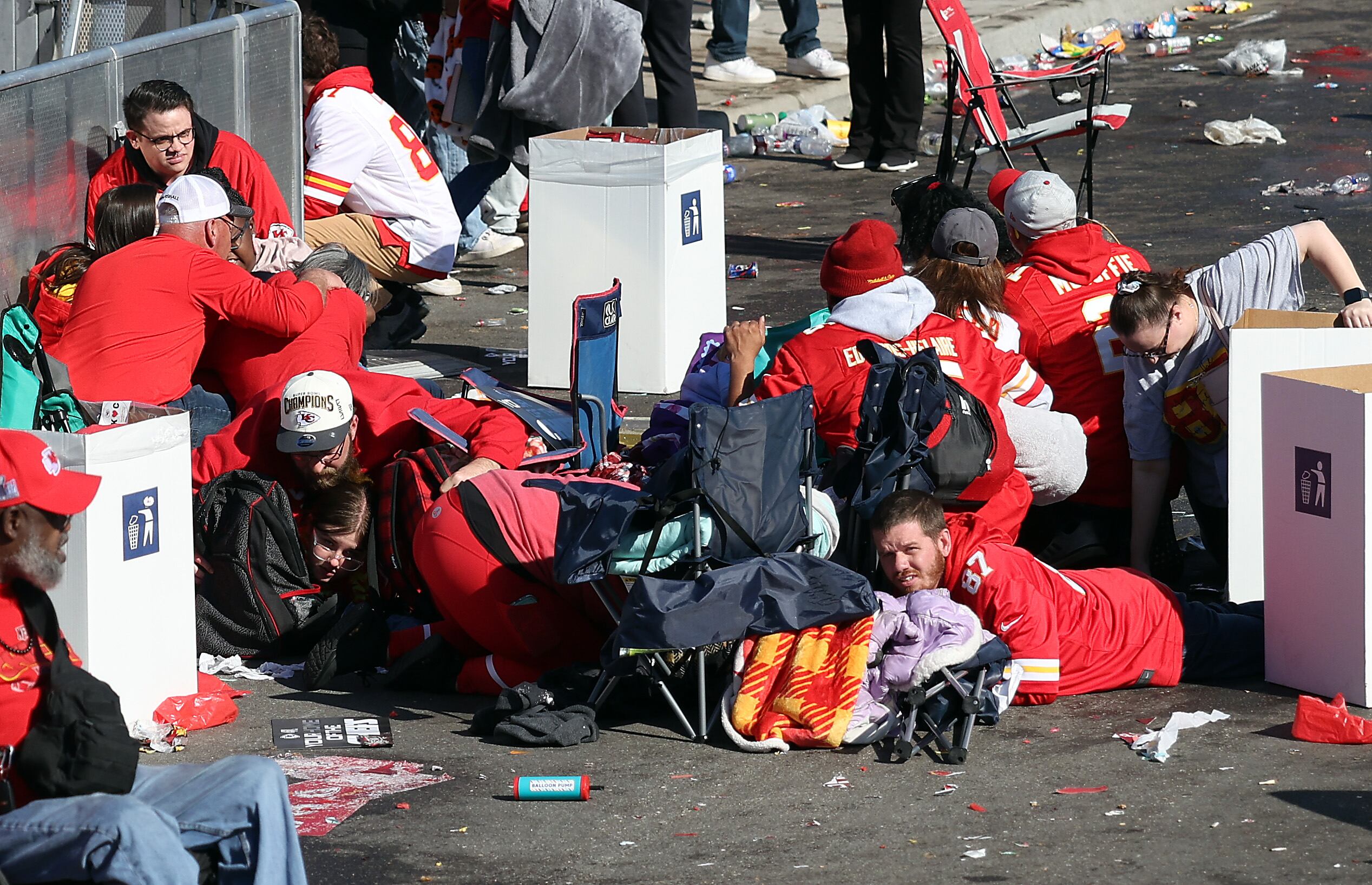 Personas se cubren por los tiroteos en Kansas, en la celebración tras la victoria de los Chiefs en la SuperBowl