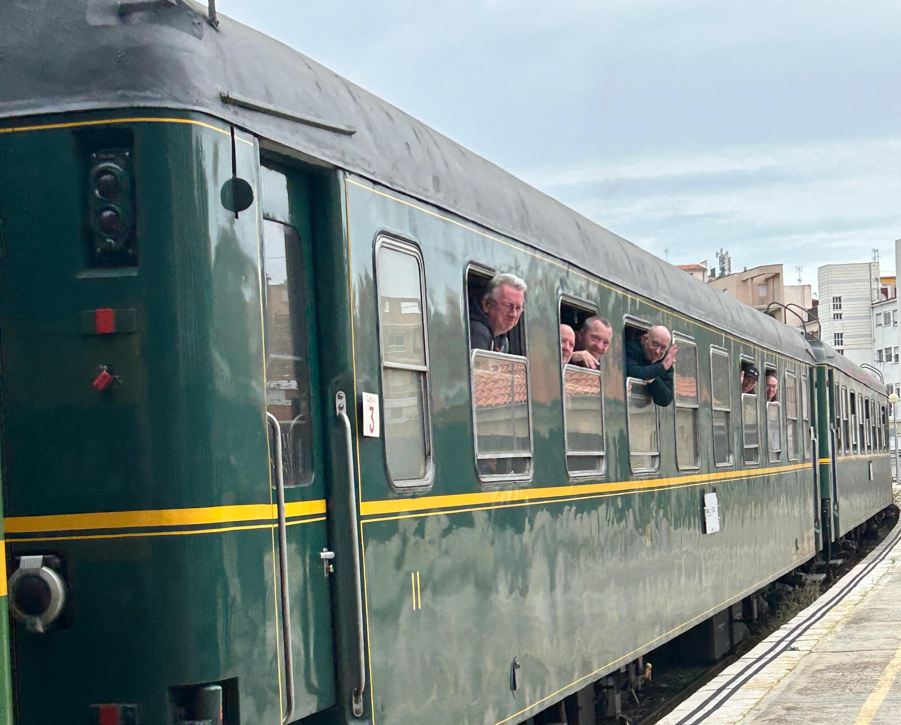 Los viajeros del tren especial saludando antes de bajar al andén de la estación de Alcoy.