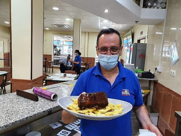 Paquito Vega, el camarero más veterano del Maypa, con un costillar asado