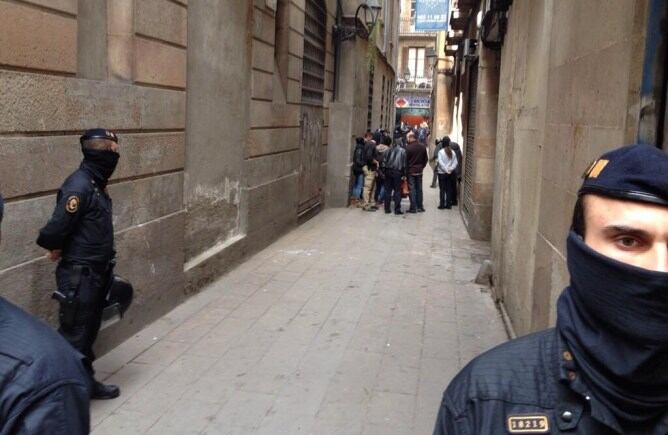 Els mossos trenquen a cop de mall la persiana d'un magatzem del carrer del Pou de la Cadena a la recerca d'armes