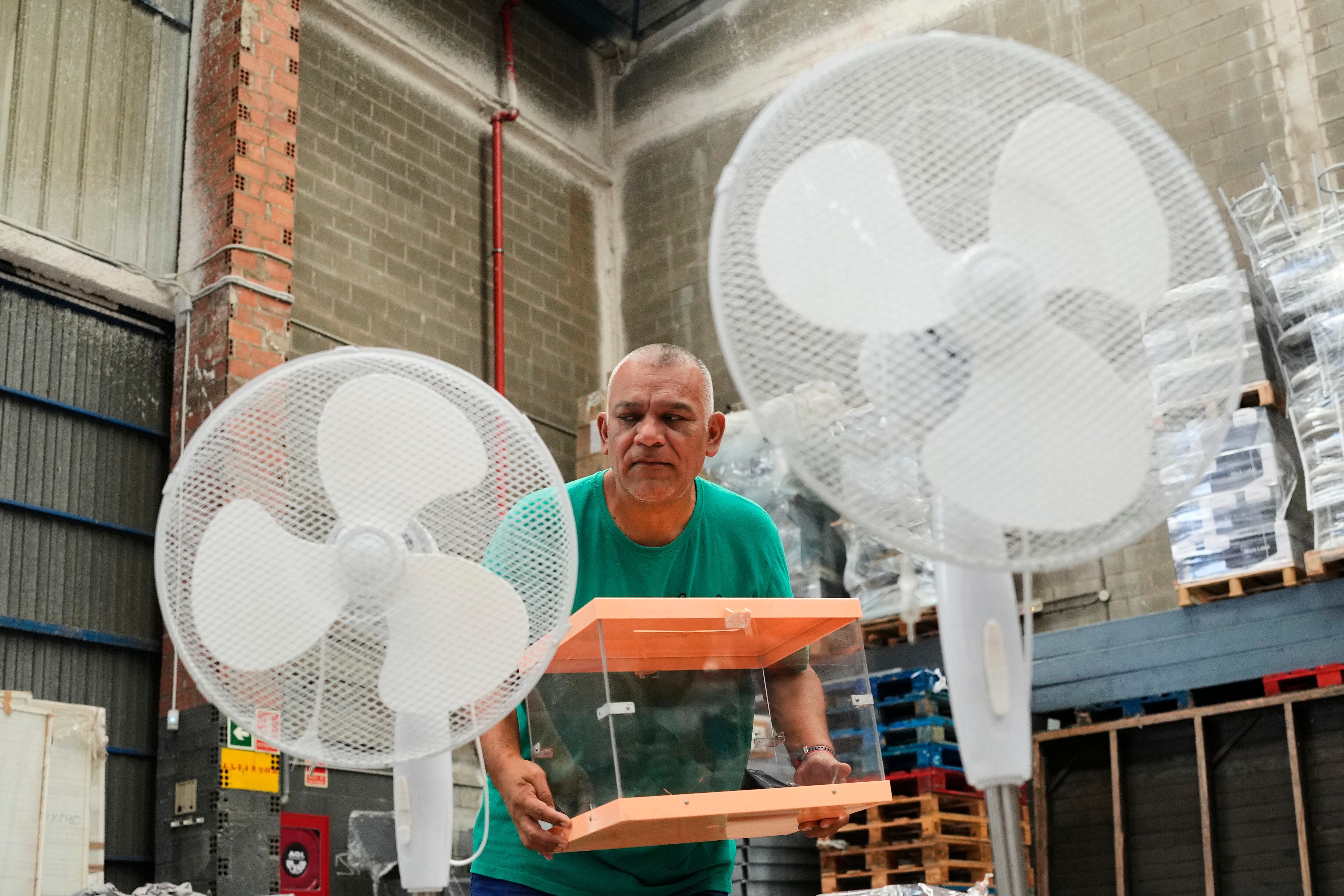 GRAFCAT2632. BARCELONA, 18/07/2023.- Un operario traslada urnas y ventiladores en los talleres municipales de Barcelona donde se está preparando el dispositivo para las próximas Elecciones Generales del 23J. EFE/Alejandro García
