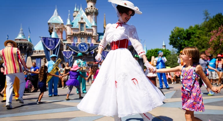 Imagen de una niña de la mano del personaje Mary Poppins en Disney World.