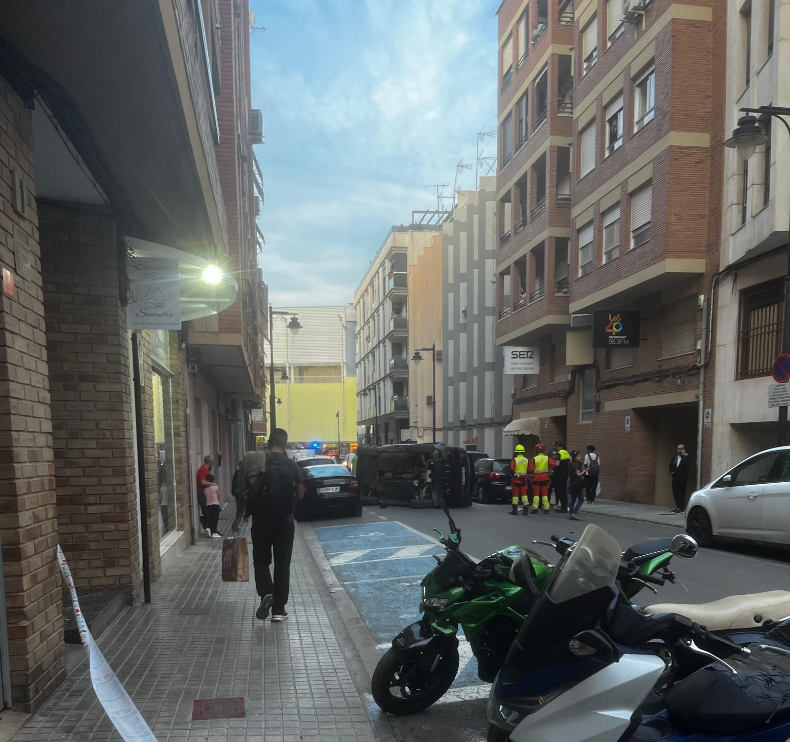 El vehículo terminó volcado en la calle Ereta de Ontinyent tras perder el control en una curva y chocar contra dos coches estacionados