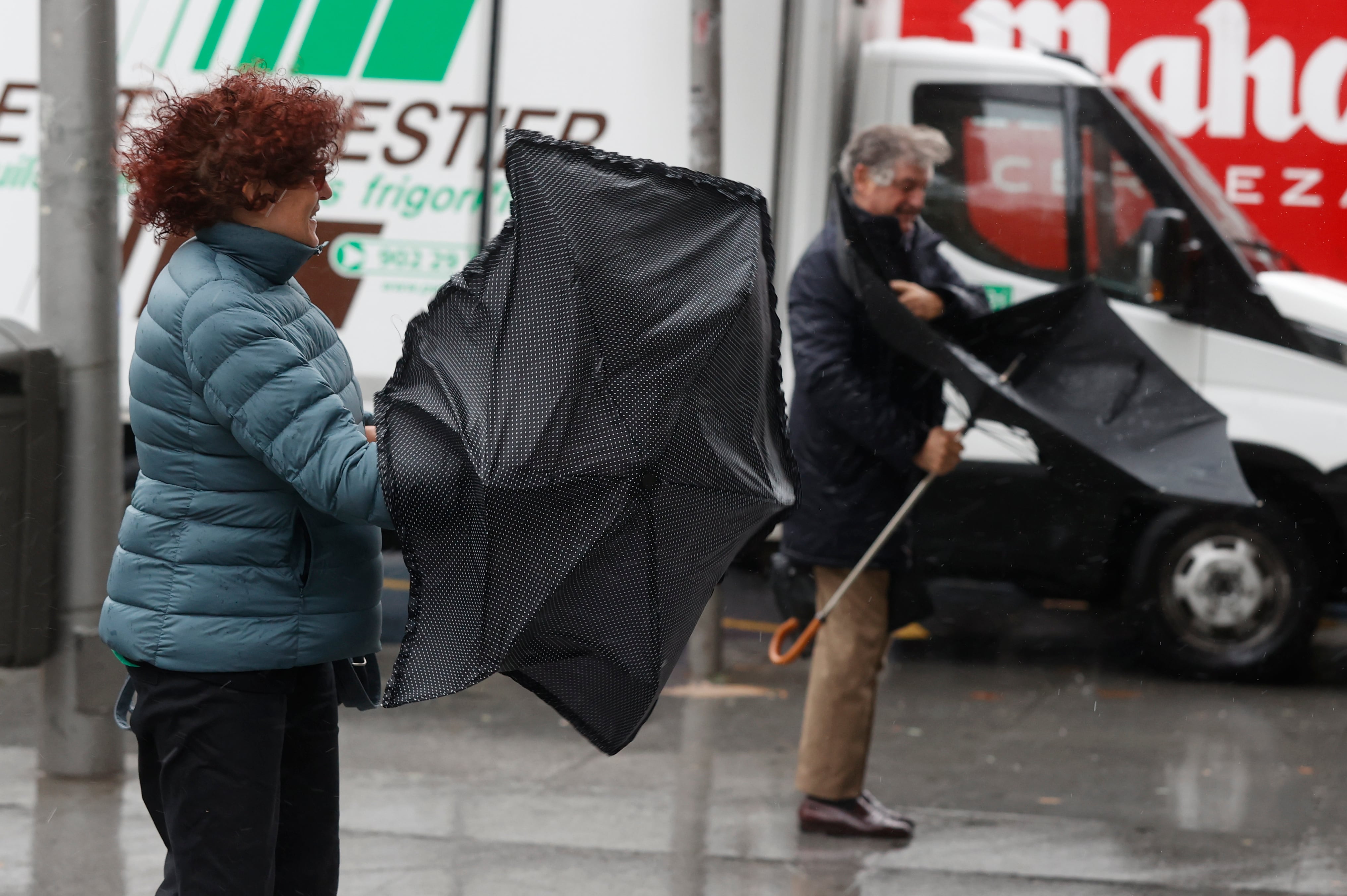 MADRID, 02/11/2023.- Viandantes se enfrentan a las fuertes rachas de viento mientras camina por una calle del centro de Madrid este jueves por el paso de Ciarán, una borrasca de alto impacto procedente del Reino Unido, que ha activado este jueves el aviso en toda España, salvo en las Canarias, por lluvias, rachas de viento de hasta 110km/h y temporal marítimo, informa la Aemet en su web. EFE/ Juan Carlos Hidalgo
