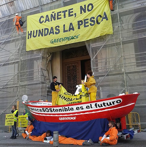 Escaladores de Greenpeace han colocado un barco de pesca artesanal a las puertas del Ministerio de Medio Ambiente para pedir al ministro Cañete su apoyo a la pesca sostenible