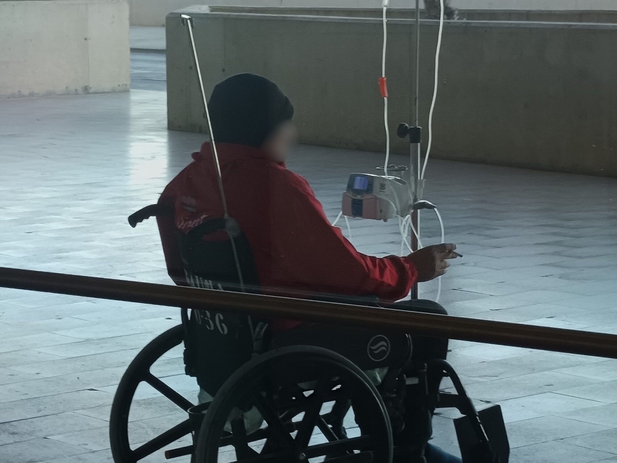 Paciente con suero fumando en espacio exterior del Hospital de Santa Lucía en Cartagena