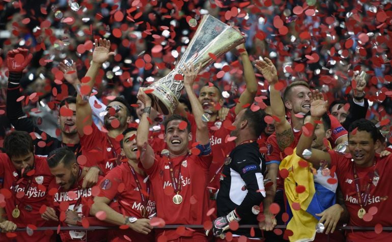 Sevilla players celebrate with throphy after the UEFA Europa League final football match between FC Dnipro Dnipropetrovsk and Sevilla FC at the Narodowy stadium in Warsaw, Poland on May 27, 2015. Sevilla FC won 2-3.    AFP PHOTO / JANEK SKARZYNSKI