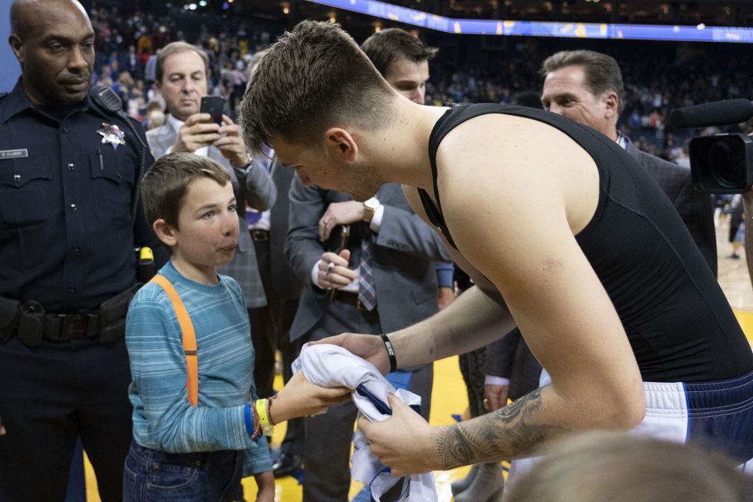 Doncic le firma la camiseta al niño. 