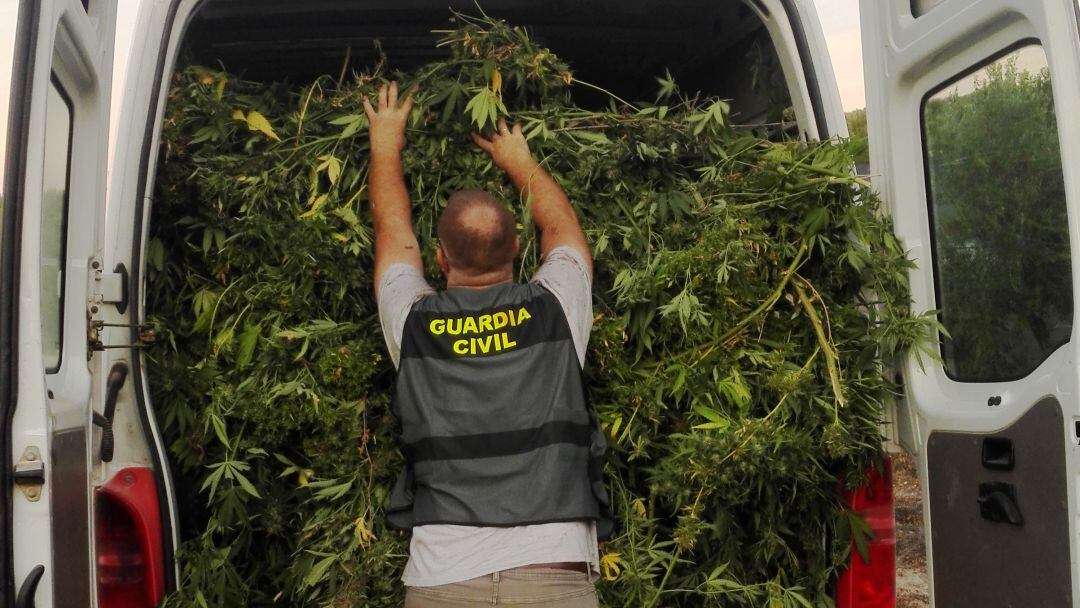 Un agente de la Guardia Civil introduce la marihuana en una furgoneta.