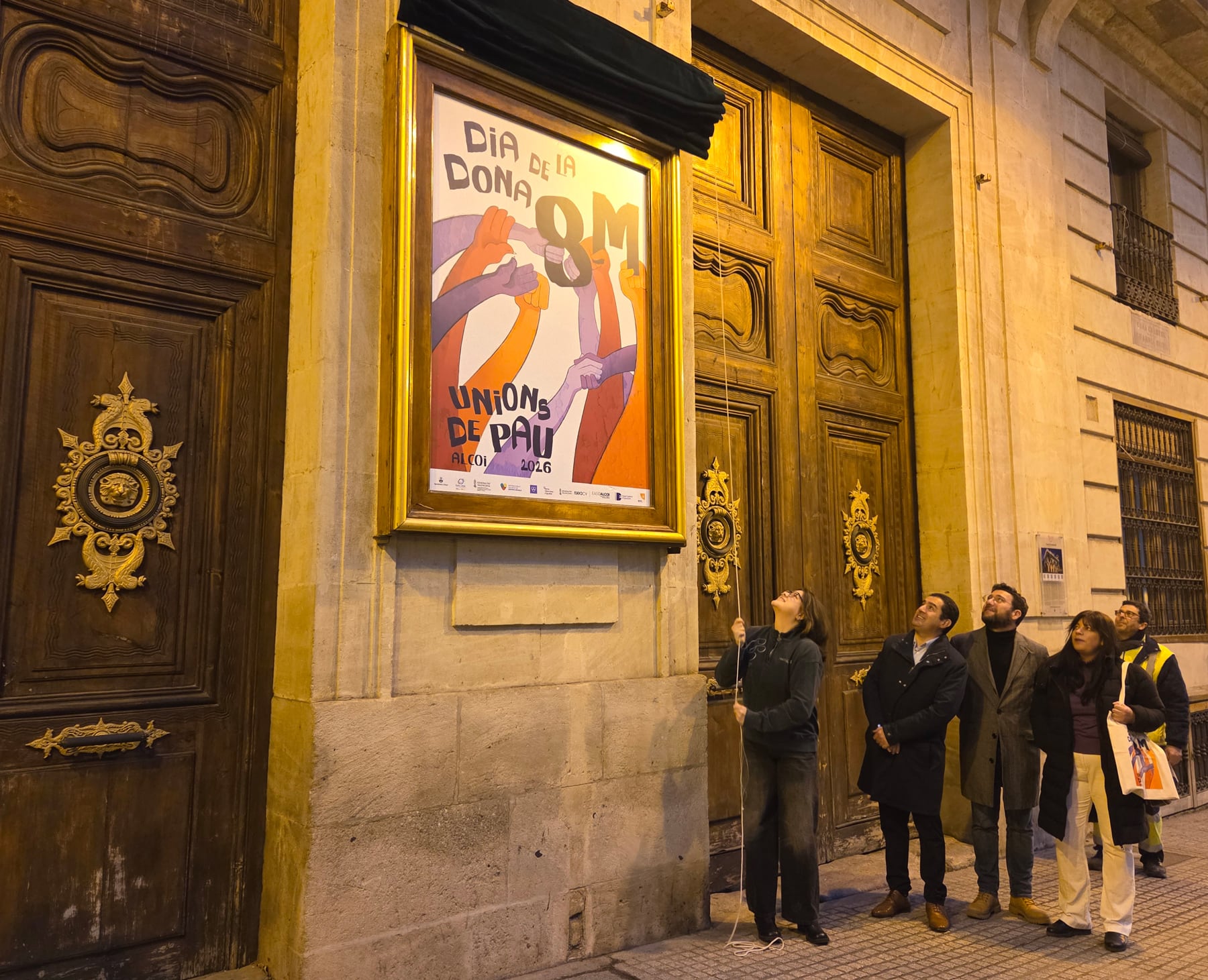 Un instante del descubrimiento del cartel en la fachada del Ayuntamiento