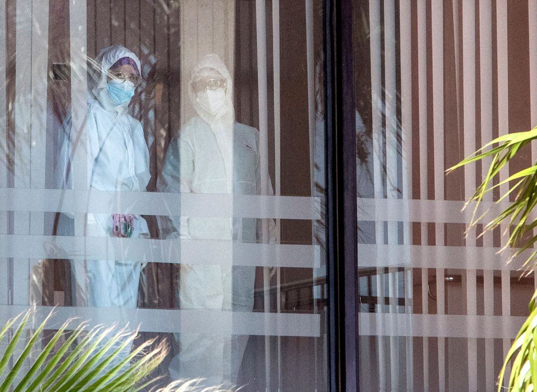 Dos trabajadores con trajes de protección hoy en el interior de la residencia de mayores Puerto Luz de Valdelagrana en El Puerto de Santa María (Cádiz). La Junta de Andalucía prepara la medicalización de esta residencia, donde las pruebas han confirmado que 106 residentes y 23 trabajadores padecen el covid-19. EFE Román Ríos