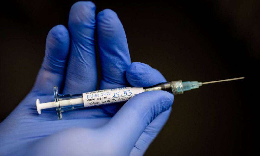 Un empleado de CureVac sostiene una jeringa.