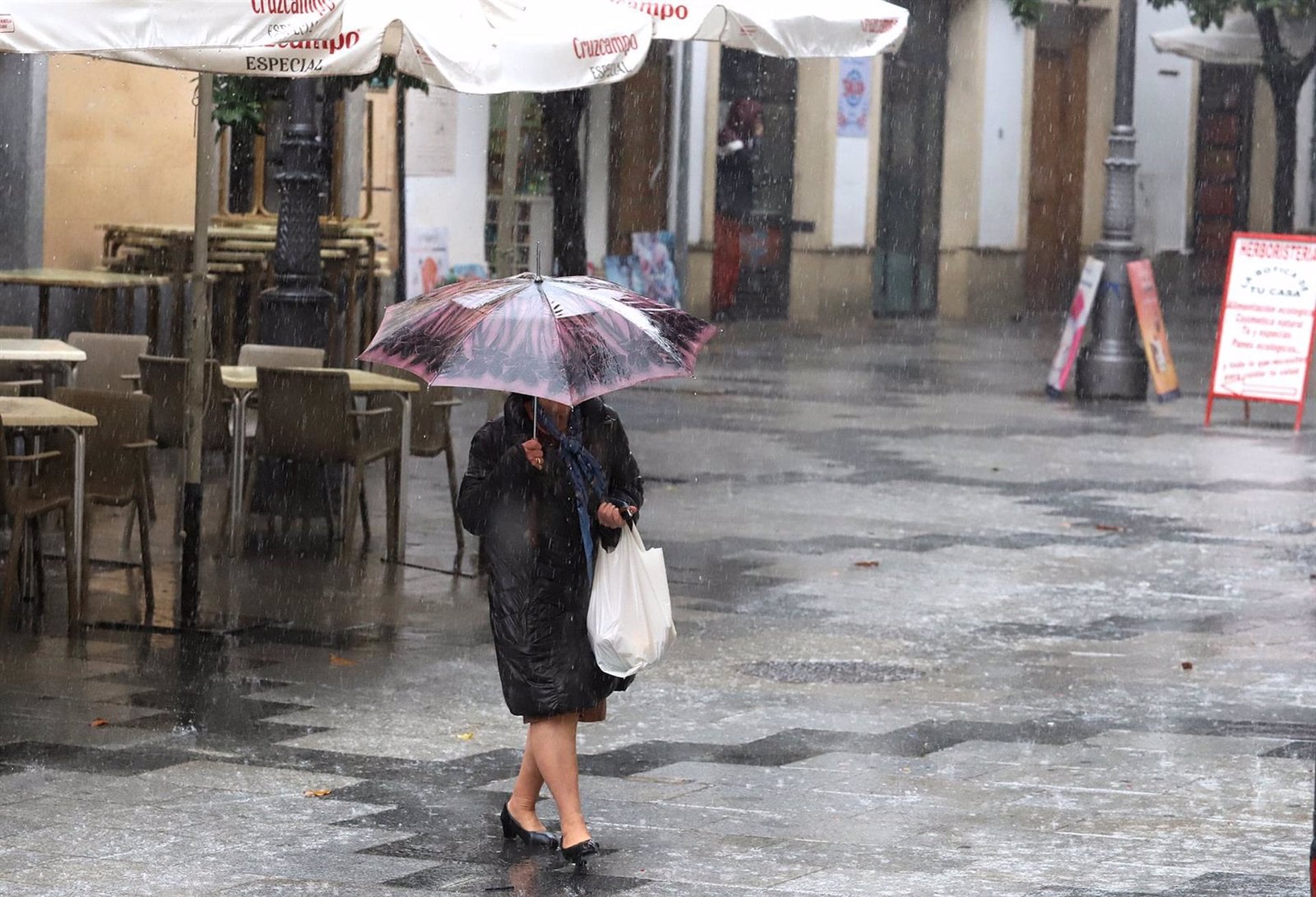 Una mujer camina con un paraguas para protegerse de la lluvia en Jerez de la Frontera