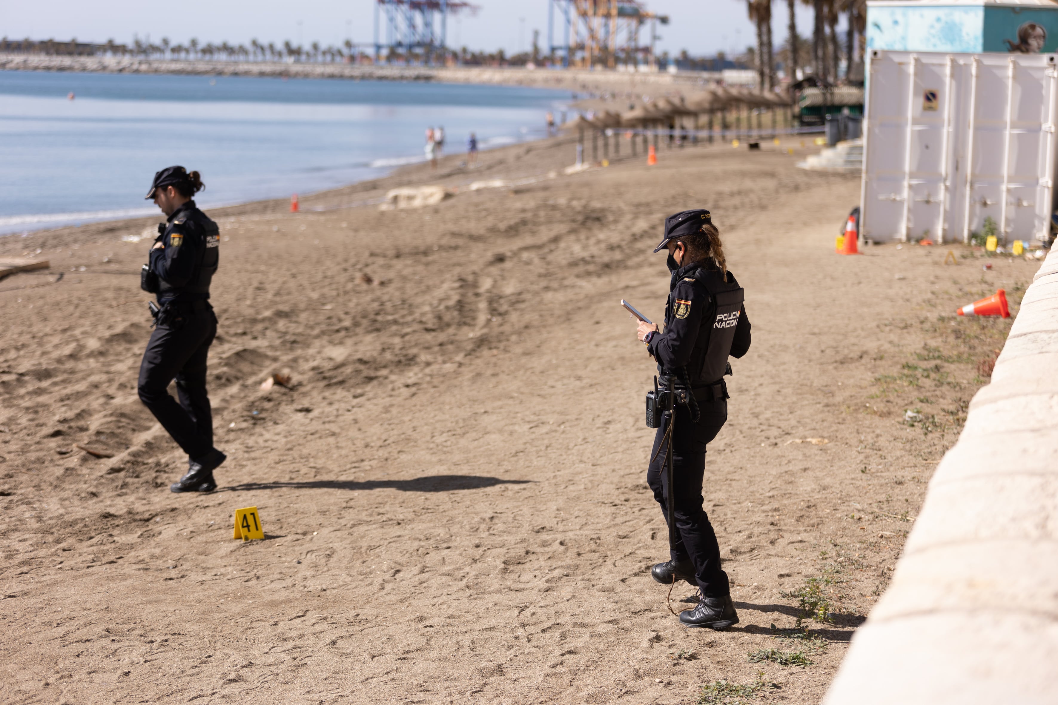 MÁLAGA, 12/03/2022.- Dos agentes de la Policía Nacional en el paseo marítimo Pablo Ruiz Picasso donde están investigando la posible muerte violenta de un varón de unos 40 años que ha aparecido a primera hora de la mañana. EFE/Carlos Díaz
