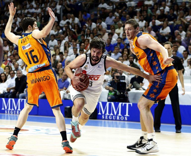 GRA414. MADRID, 04/06/2015.- El base del Real Madrid Sergio Llull (c) pugna un balon con el ucraniano Serguéi Lischuk (d) y Guillem Vives, del Valencia Basket, durante el primer partido de las semifinales de la Liga ACB que se juega esta tarde en el Palacio de los Deportes de la Comunidad de Madrid. EFE/Javier Lizón