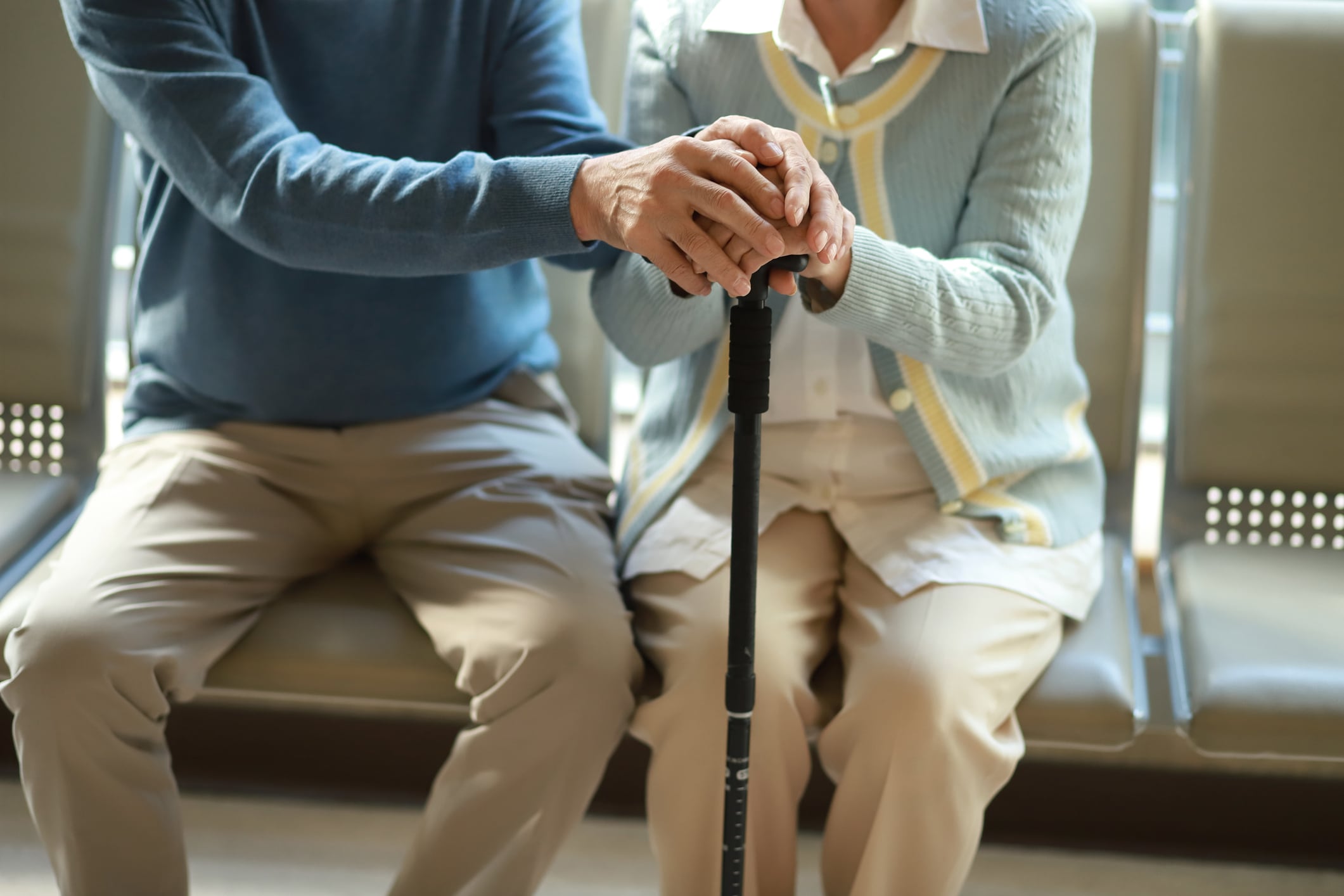 Una pareja de ancianos sosteniendo un bastón