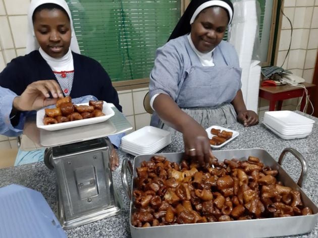 Dos hermanas preparando las bandejas de pestiños