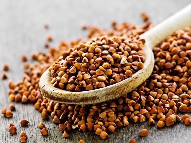Buckwheat seeds on wooden spoon in closeup