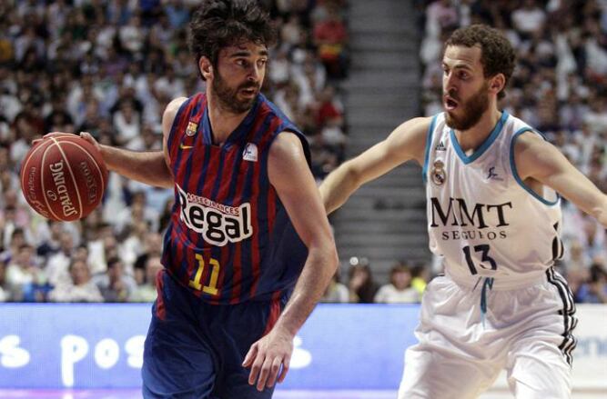 El escolta del FC Barcelona Regal, Juan Carlos Navarro controla el balón ante el base del Real Madrid Sergio Rodríguez, durante el segundo partido de la final de la Liga Endesa