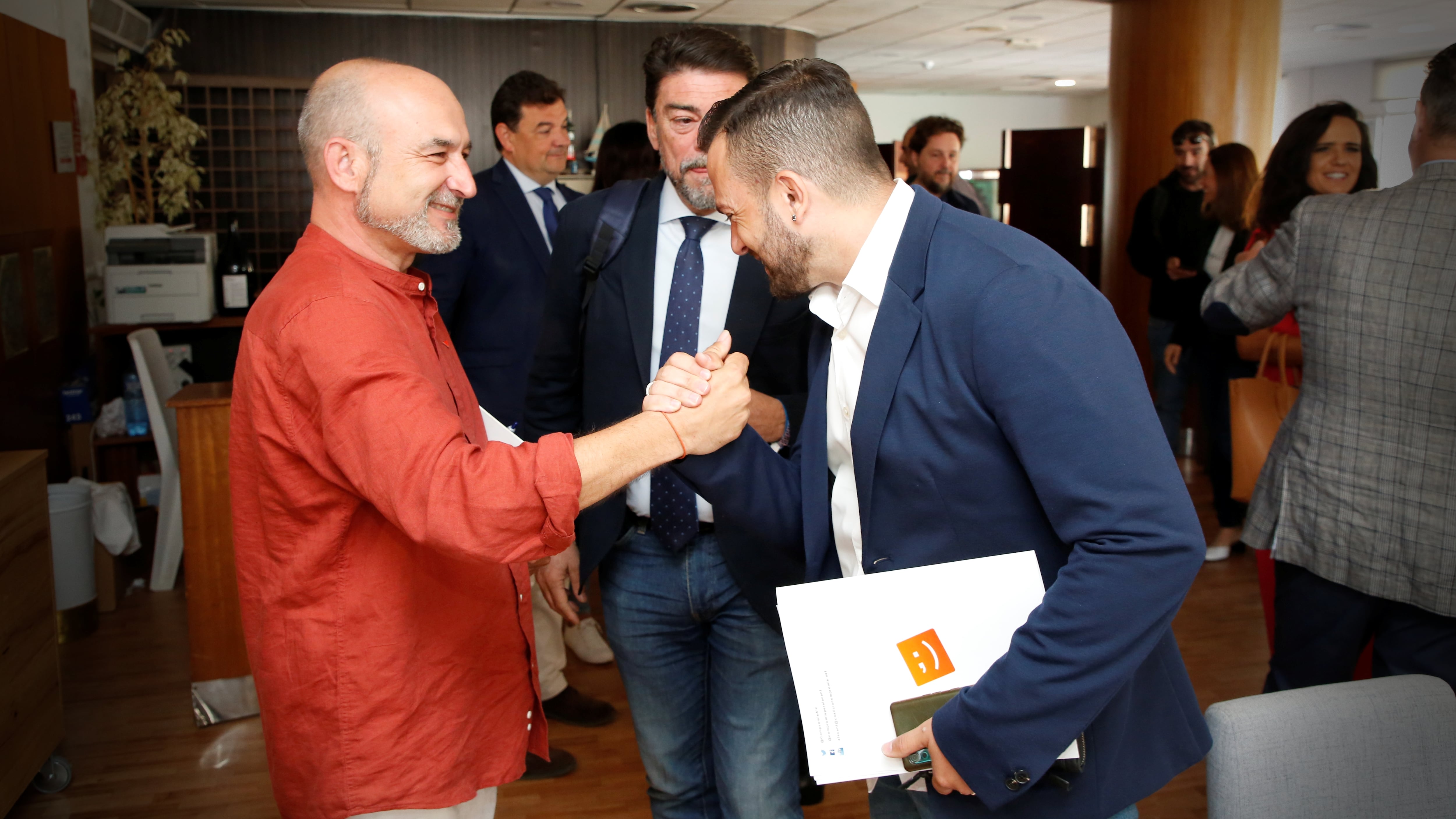 Manolo Copé, candidato de Unides per Alacant, y Rafa Más, candidato de Compromís, se saludan frente al alcalde de Alicante, Luis Barcala, minutos antes del comienzo del debate electoral de la SER