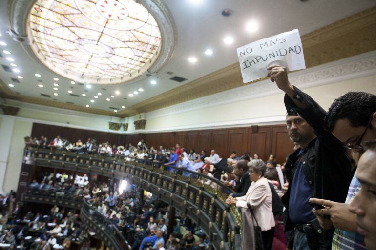 Asistentes a una sesión de la Asamblea Nacional venezolana en Caracas muestran carteles exigiendo medicinas en medio de la escasez que vive el país 